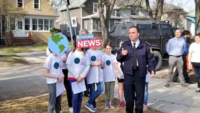 Danny Smyth stands beside several students. Behind them is the WPS armoured vehicle.